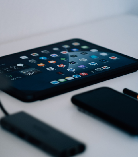 tablet-lays-on-a-white-table-with-screen-lit-by-app-icons 1